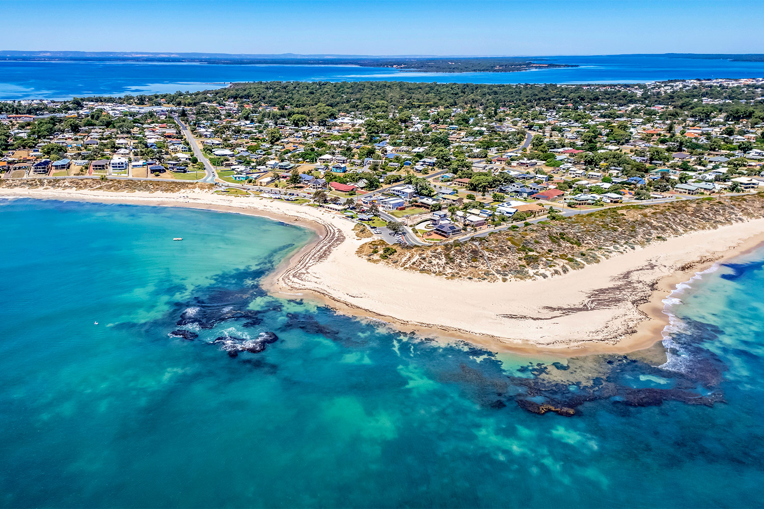 Drone view of the beautiful blue coastal and estuary waters surrounding Waratah Village Community