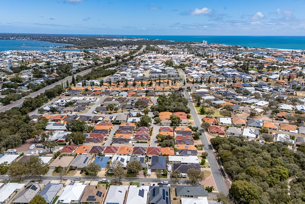 Aerial view of Waratah Village with blue ocean waters and Mandurah Estuary in Wannanup, WA